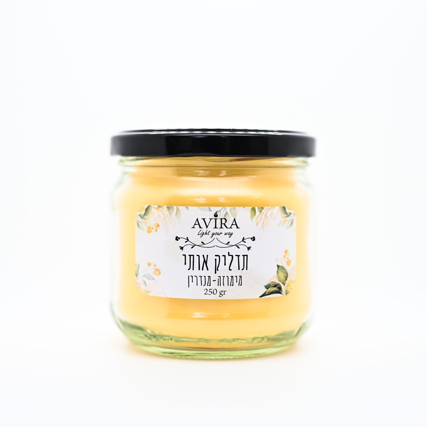 נר ריחני מומלץ 250 גרם שעווה בצבע צהוב-כתמתם בצנצנת בניחוח מימוזה-מנדרין עם מדבקה לבנה שעליה כתוב: תדליק אותי