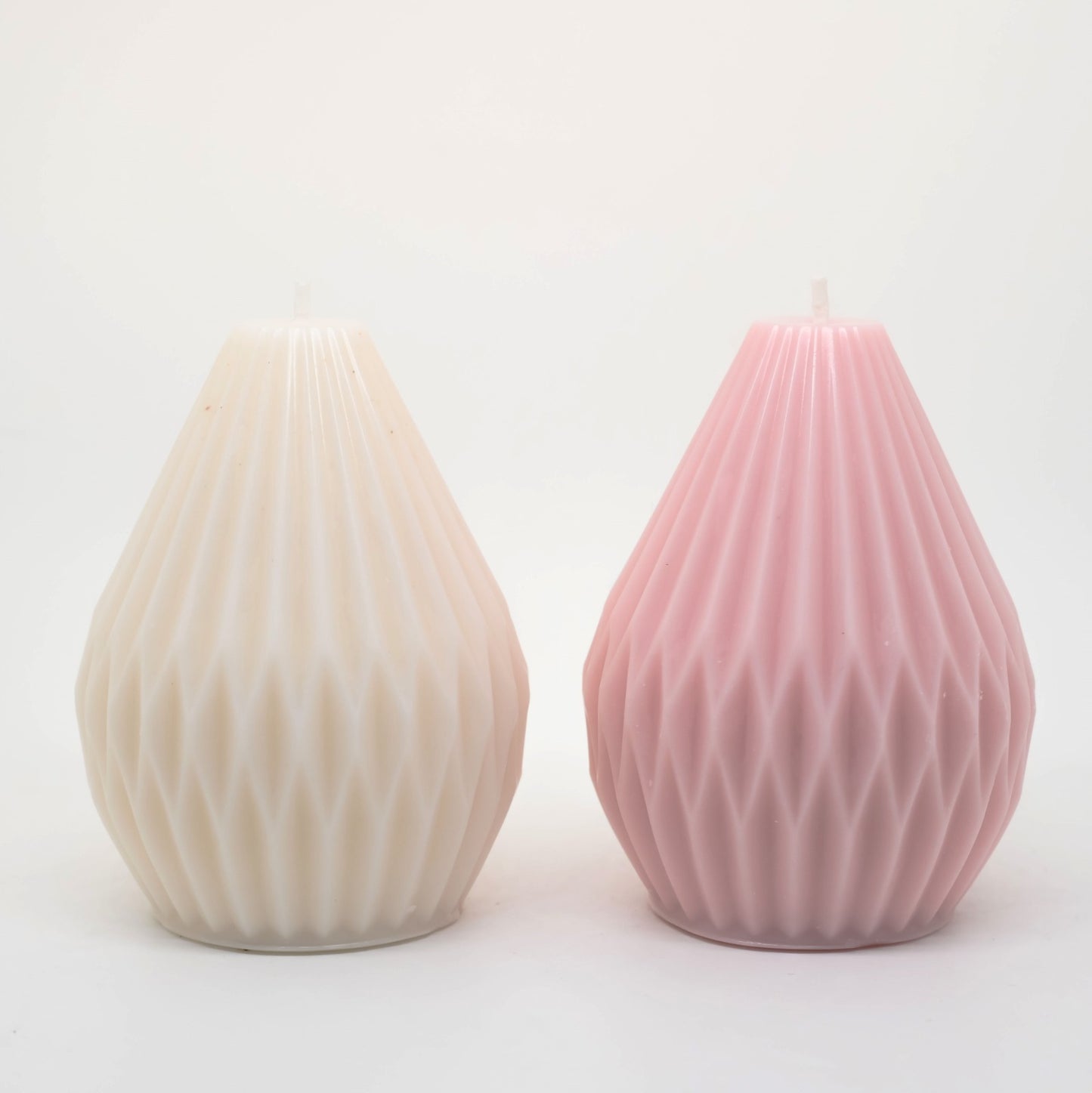 שני נרות ריחניים מעוצבים בצורת אגסים מעוטרים עם פסים , השמאלי בצבע לבן והימיני בצבע ורוד