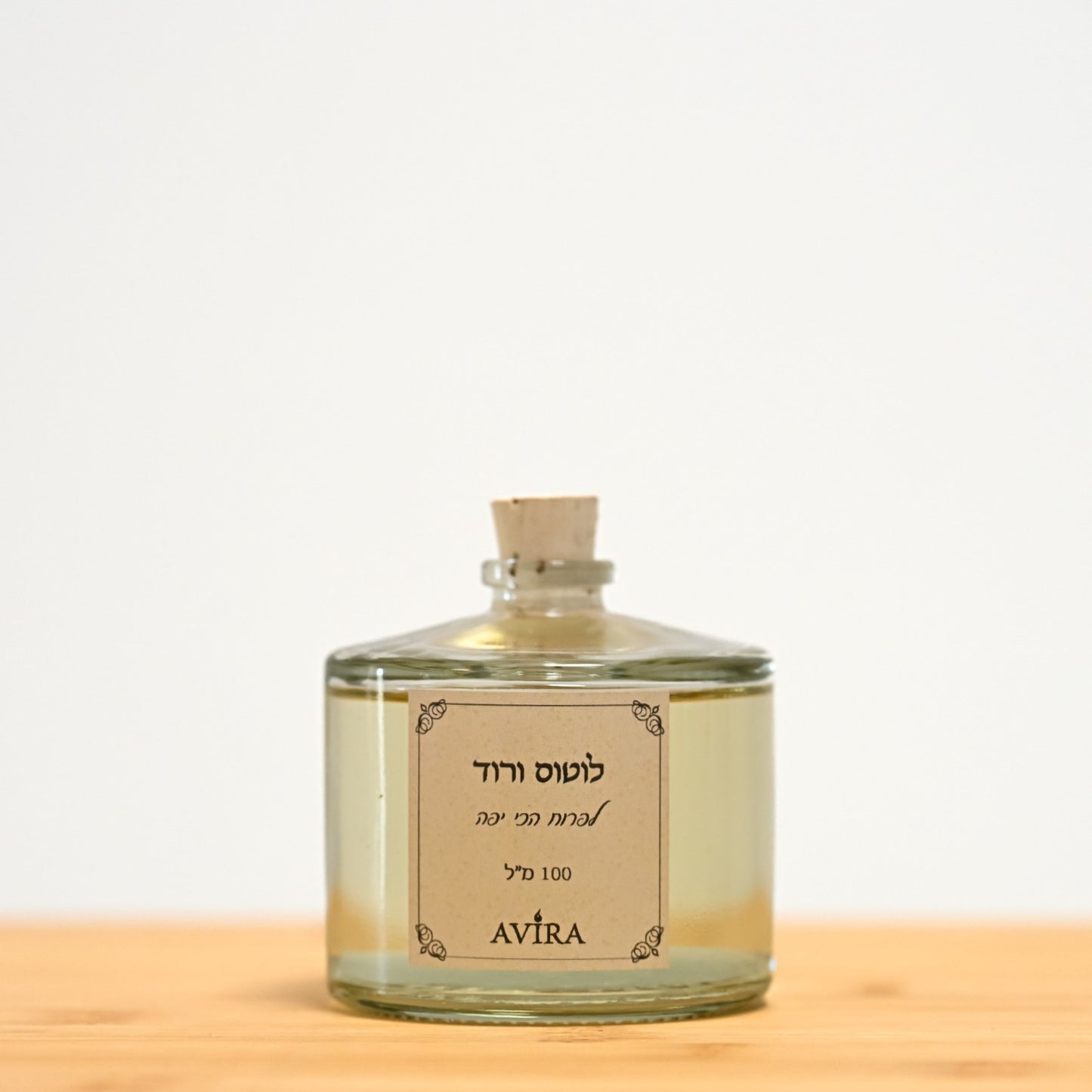 מפיץ ריח 100 מ"ל בניחוח לוטוס ורוד, בכלי זכוכית עגלגל שקוף, אטום בפקק שעם – ועליו הכיתוב "לפרוח הכי יפה".