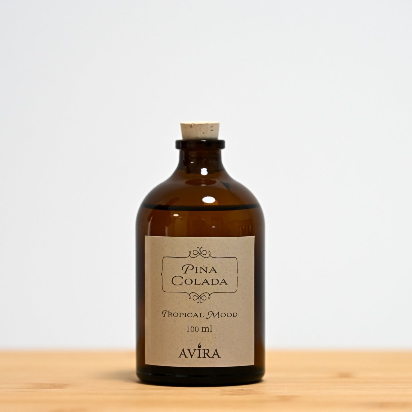 מפיץ ריח 100 מ"ל בניחוח פינה קולדה, בכלי זכוכית חום ("בקבוק רוקחים") אטום בפקק שעם – ועליו מדבקה עם הכיתוב "TROPICAL MOOD".