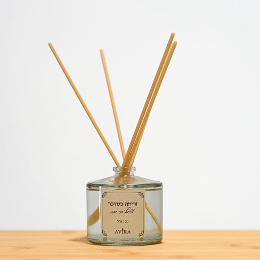 מפיץ ריח 100 מ"ל בניחוח זריחה במדבר עם מקלות דמויי עץ, בכלי זכוכית עגלגל שקוף, אטום בפקק שעם – ועליו הכיתוב "לשאוף הכי גבוה".