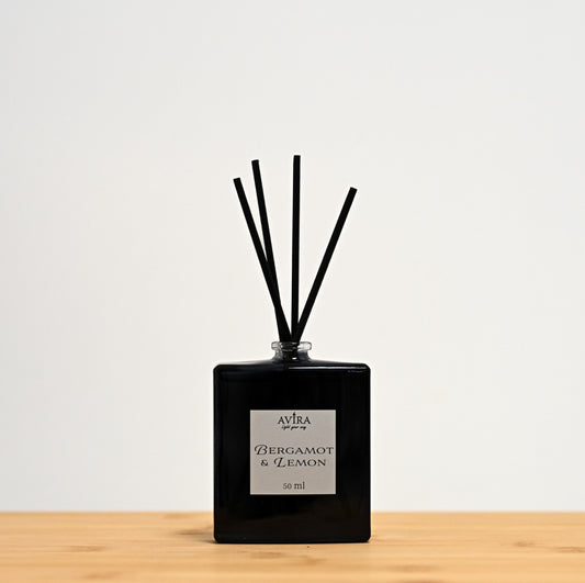 מפיץ ריח 50 מ"ל בניחוח ברגמוט ולימון עם מקלות שחורים, בכלי זכוכית כחול כהה, בקבוק בושם מרובע. הכלי נאטם עם פקק שעם, ובחזית מדבקה ריבועית בצבע שמנת.