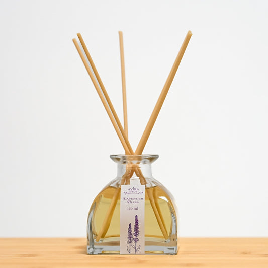 מפיץ ריח 150 מ"ל בניחוח לבנדר מפנק עם מקלות דמויי עץ, בכלי זכוכית יפהפה בצורת פירמידה עם פאות מקומרות אטום בפקק שעם – ועליו איור סגלגל של צמחי לבנדר.