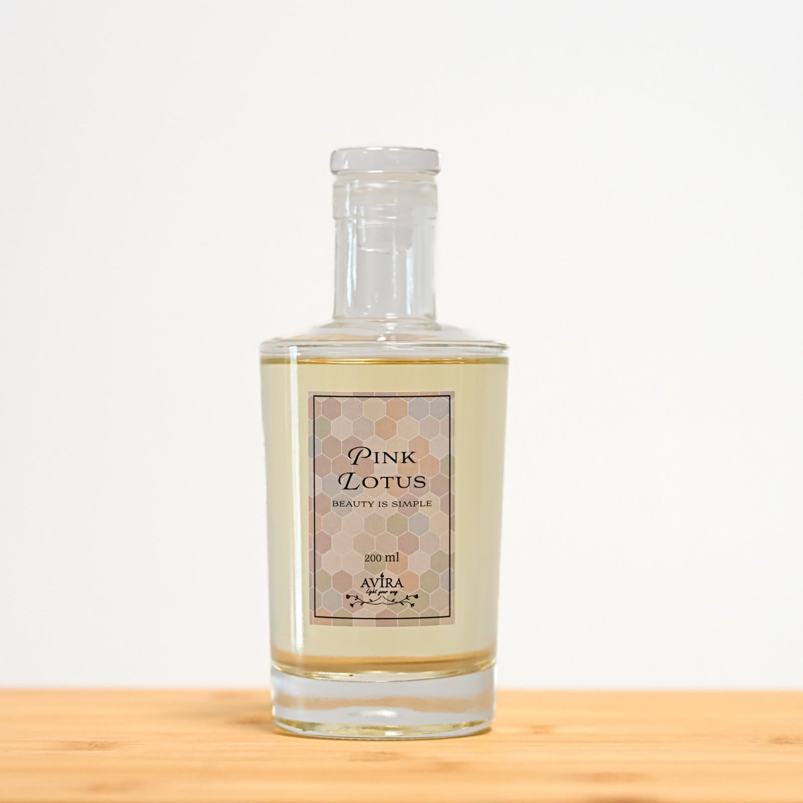 מפיץ ריח 200 מ"ל בניחוח לוטוס ורוד בכלי זכוכית שקוף, אטום בפקק וינילוק – ועליו הכיתוב "BEAUTY IS SIMPLE".