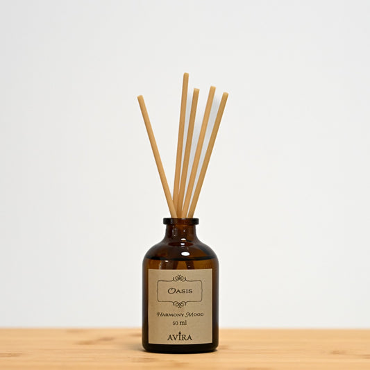 מפיץ ריח 50 מ"ל בניחוח אואזיס עם מקלות דמויי עץ, בכלי זכוכית חום ("בקבוק רוקחים") אטום בפקק שעם – ועליו מדבקה עם הכיתוב "HARMONY MOOD".