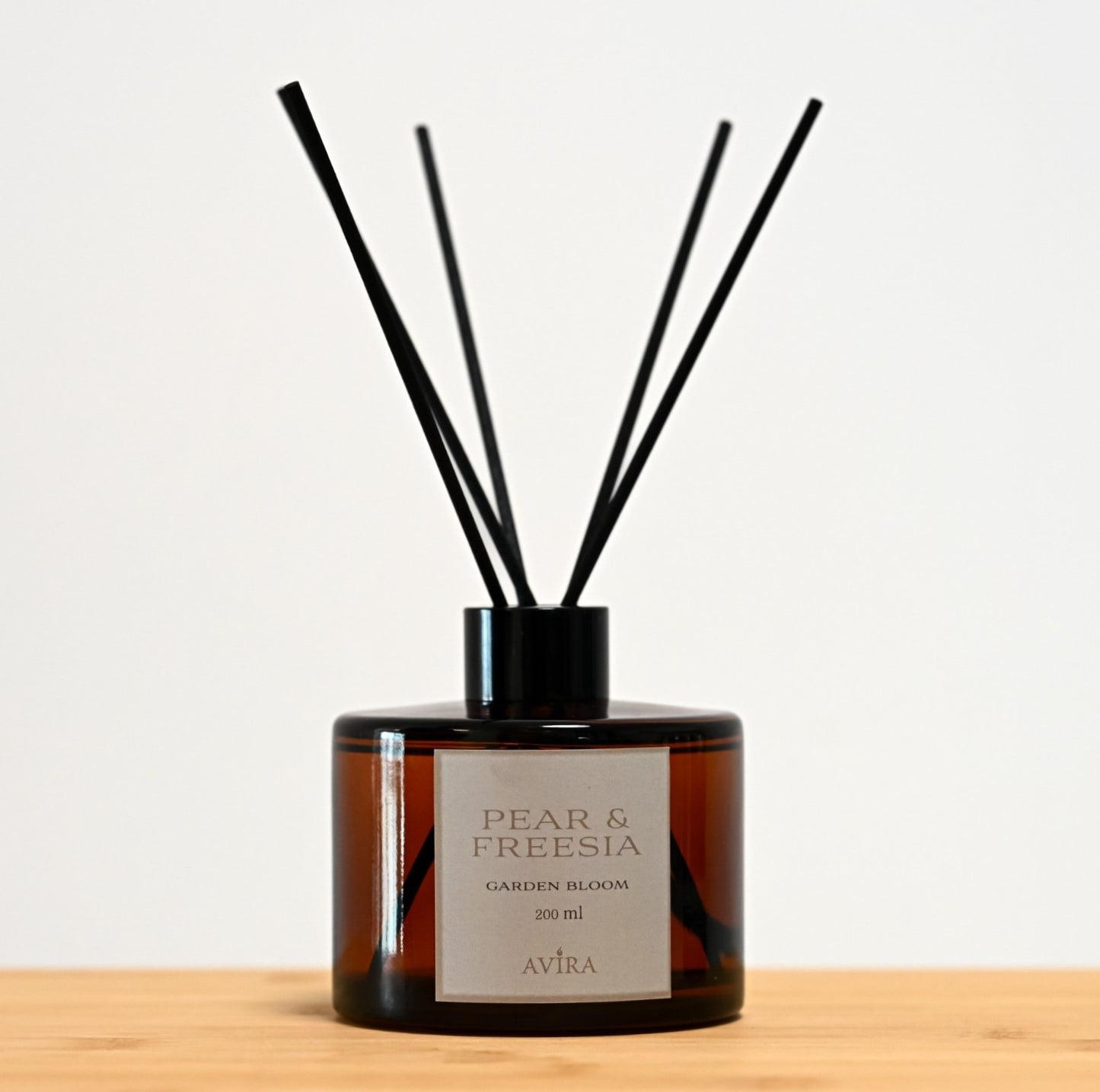 מפיץ ריח 200 מ"ל בניחוח אגס ופרזיה עם מקלות שחורים, בכלי עגלגל מזכוכית חומה אמבר-בוקה – אטום בפקק ומלווה בקולר שחור. בחזית הכלי – מדבקה עם הכיתוב "GARDEN BLOOM".