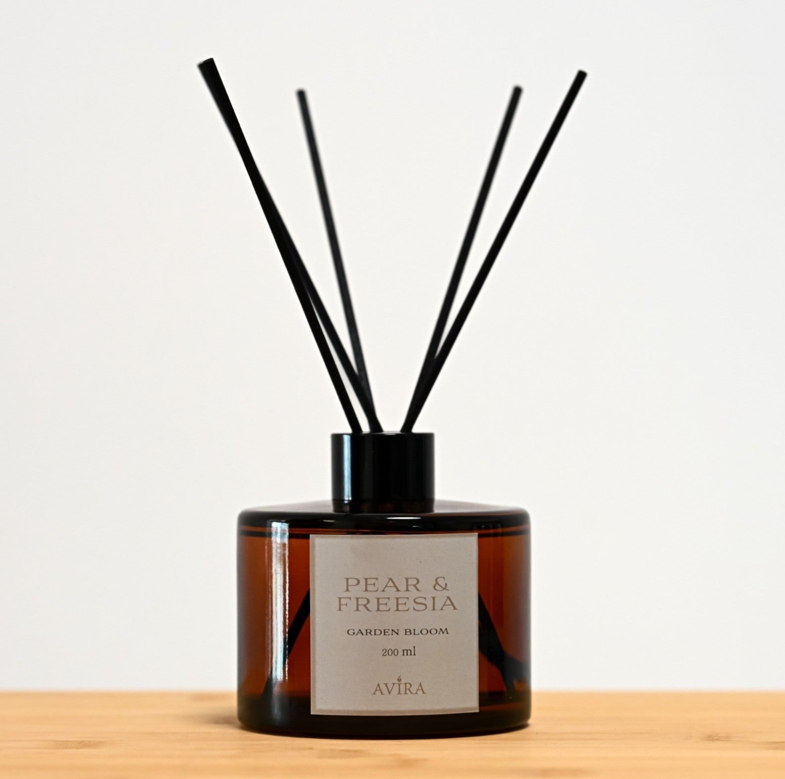 מפיץ ריח 200 מ"ל בניחוח אגס ופרזיה עם מקלות שחורים, בכלי עגלגל מזכוכית חומה אמבר-בוקה – אטום בפקק ומלווה בקולר שחור. בחזית הכלי – מדבקה עם הכיתוב "GARDEN BLOOM".