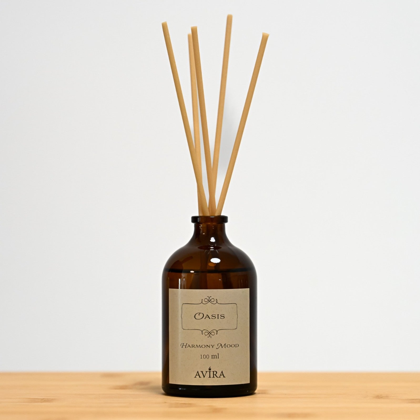 מפיץ ריח 100 מ"ל בניחוח אואזיס עם מקלות דמויי עץ, בכלי זכוכית חום ("בקבוק רוקחים") אטום בפקק שעם – ועליו מדבקה עם הכיתוב "HARMONY MOOD".