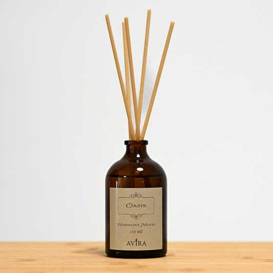 מפיץ ריח 100 מ"ל בניחוח אואזיס עם מקלות דמויי עץ, בכלי זכוכית חום ("בקבוק רוקחים") אטום בפקק שעם – ועליו מדבקה עם הכיתוב "HARMONY MOOD".