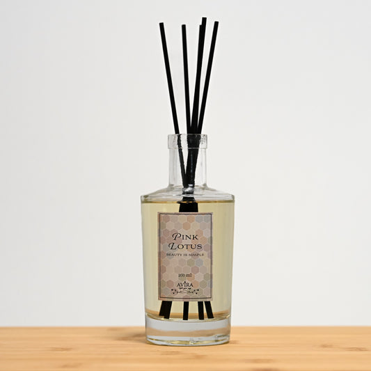 מפיץ ריח 200 מ"ל בניחוח לוטוס ורוד עם מקלות שחורים בכלי זכוכית שקוף, אטום בפקק וינילוק – ועליו הכיתוב "BEAUTY IS SIMPLE".