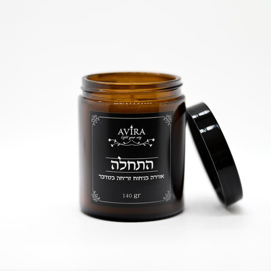 נר 140 גרם בניחוח זריחה במדבר בתוך צנצנת חומה יוקרתית - ועל הצנצנת מדבקה שחורה עם הכיתוב "התחלה"