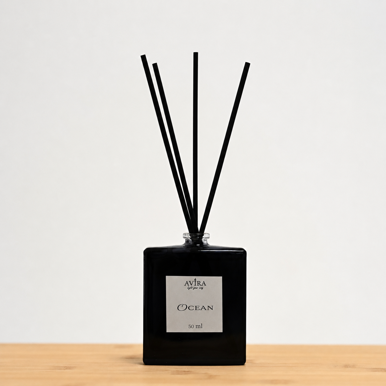 מפיץ ריח 50 מ"ל בניחוח אושן עם מקלות שחורים, בכלי זכוכית כחול כהה, בקבוק בושם מרובע. הכלי נאטם עם פקק שעם, ובחזית מדבקה ריבועית בצבע שמנת.